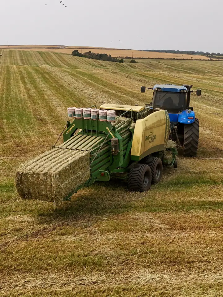 Enfardadora Krone soltando um fardo prismático na lavoura